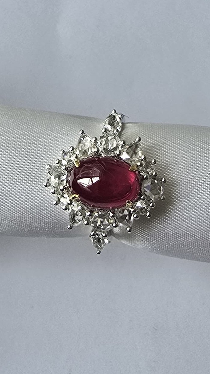 Ruby cabochon ring with diamond halo